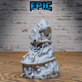 Skeleton pressed against a rough stone pillar, arms reaching around it, with small skulls embedded in the rocky base and thick chain rings visible at multiple heights. Sculpt by Epic Miniatures.