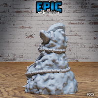 Abandoned Skeleton miniature by Epic Miniatures — skeletal figure bound to a craggy rock formation with coiled chain links and skull details emerging from the sculpted base.