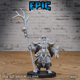 Stocky orc shaman gripping a tall antler staff wrapped in bone fetishes and skulls, wearing layered hide armour with a beast-skull pauldron, one hand raised in invocation. Sculpt by Epic Miniatures.