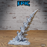 A single tall bone spike terrain piece leaning dramatically to one side, composed of twisted fused bone columns with jagged shard growths, rising from a skull-littered rubble base. Sculpt by Epic Miniatures.