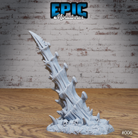 A single bone spike terrain piece viewed from a slightly lower angle, showing the full height of the twisted fused bone columns and the cluster of shard growths at the base, with skulls embedded in the rubble. Sculpt by Epic Miniatures.