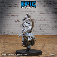 Cloaked male figure raising a short sword overhead mid-spin, second blade held low, billowing robes with detailed folds, weighted pouches at the hip, on a plain round base. Sculpt by Epic Miniatures.