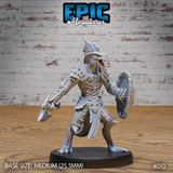 Lizardfolk warrior facing forward, mouth open showing rows of teeth, dorsal fin-crest raised, wielding a hand axe and a broad tortoiseshell shield, wearing spiked pauldrons and bone-plate armour. Sculpt by Epic Miniatures.
