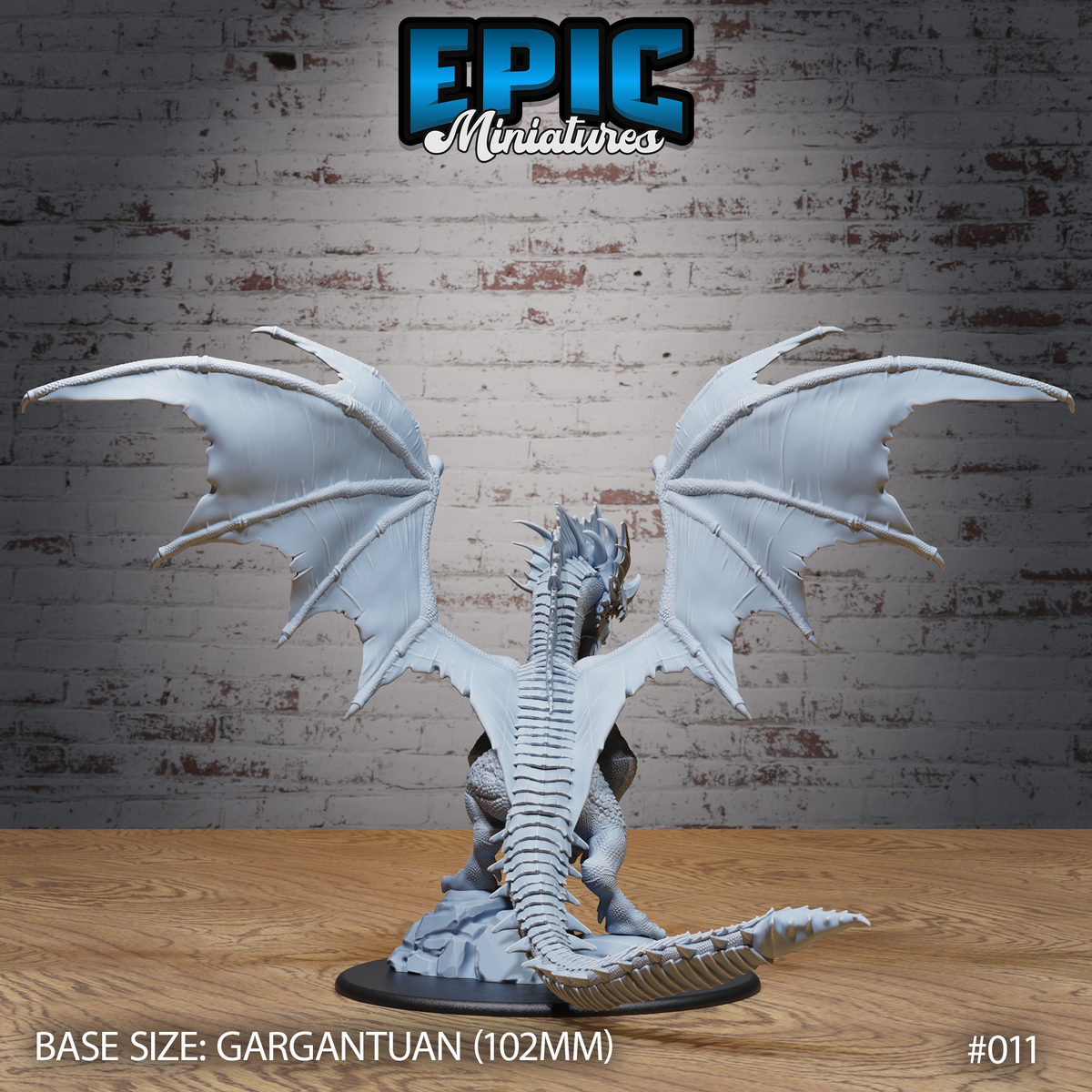 Ancient Blue Dragon seen from behind, deeply ridged spine and individually scaled back fully visible, broad wings stretched to their full span from wingtip to wingtip, tail sweeping low across a rocky base. Sculpt by Epic Miniatures.