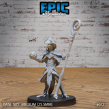 Lizardfolk sorcerer miniature facing forward, horned angular helm, diamond-motif chest plate, raising an orb in one clawed hand and gripping a tall spiral-topped staff in the other. Sculpt by Epic Miniatures.