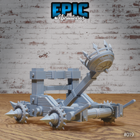 Dark Catapult with throwing arm angled upward and barbed basket visible from the side, revealing iron banding, counterweight housing, and outward-facing axle spikes. Sculpt by Epic Miniatures.