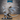 Adult white dragon miniature standing upright on a plain oval base, head raised, wings spread wide with visible bone spars and membrane striations, long serrated tail sweeping to the right. Sculpt by Epic Miniatures.