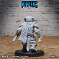 Dog-headed warrior seen from behind, showing a stitched cloak, reinforced knee-guards, a hanging blade, and detailed fur texture across the arms and back. Sculpt by Epic Miniatures.
