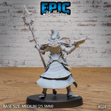 Dark elf wizard seen from behind, hooded coat flaring at the hem, barbed staff extended upward and spellbook clutched at her side. Sculpt by Epic Miniatures.