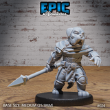 Stocky canine-headed warrior lunging forward with a two-handed spear, wearing stitched leather armour, buckled belt, and shoulder cape. Snarling expression, fangs bared. Sculpt by Epic Miniatures.