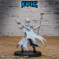 Skeleton wizard seen from behind, hooded robes billowing with torn hem, one arm raised holding an orb-topped staff, the other extended with flame effect. Sculpt by Epic Miniatures.