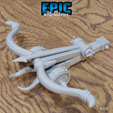 Ballista miniature by Epic Miniatures, viewed from above at an angle, showing curved horn-like limbs, wound cord wrappings, studded iron fittings, and a layered timber stock with cocking mechanism.