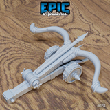 Ballista miniature by Epic Miniatures viewed from the side, showing the full length of the timber rail, the swept limbs curving outward, studded wheel-like grip fittings, and a bolt nocked on the rail.