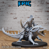 Lizardfolk warrior in segmented armour, jaw open in a war-cry, riding a large spiked crocodilian with open jaws and banded bridle. Mounted on a 51mm oval base. Sculpt by Epic Miniatures.