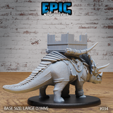Rear view of the armoured triceratops showing scaled tail, rope-lashed saddle rigging, and the four-posted timber battle platform with spiked battlements mounted across its back. Sculpt by Epic Miniatures.
