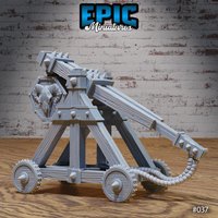 Siege catapult showing the full length of the throwing arm with spiked upper edge, heavy counterweight block, banded timber beams, and coiled rope sling hanging from the arm. Sculpt by Epic Miniatures.