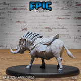 Armoured warthog miniature facing left, showing the saddle detail across its broad back, overlapping spine plates, thick bristled hide, and fitted head barding with curved tusks. Sculpt by Epic Miniatures.