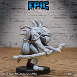 Frogfolk archer miniature crouching in a wide stance, gripping a rope-wound bo staff across the body, with a bristling arrow quiver on its back and a billowing stitched cloak. Fanged expression, crowned with bony spines. Sculpt by Epic Miniatures.