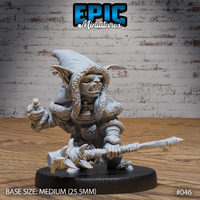 Snarling goblin shaman crouching low, holding a blade-lashed spear horizontally and clutching a small totem, wearing a heavy fur-trimmed hooded cloak over layered leather armour. Sculpt by Epic Miniatures.