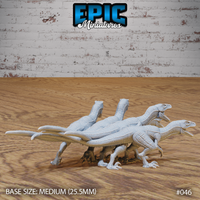 Three raptor miniatures in low stalking poses, bodies horizontal and necks extended, tails held stiffly outward for balance, detailed scaled skin visible across the flanks. By Epic Miniatures.