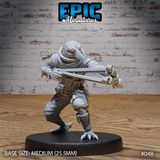 Kenku bird-folk miniature in a wide combat stance, both arms extended forward gripping a large slingshot, wearing layered wraps, a hooded cloak, and a utility harness with pouches. Taloned feet and avian beak visible. Sculpt by Epic Miniatures.