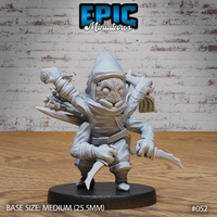 Hooded spider folk assassin leaning forward aggressively, clawed hands gripping multiple daggers, fur-covered round face visible beneath deep cowl, bandaged forearms, robes and sash, plain round base. Sculpt by Epic Miniatures.