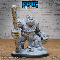 Massive stone golem crouching forward with fists clenched, raising a tall staff carved with stacked faces and masks. Rocky cracked body with cloth wrappings. Skull and debris on base. Sculpt by Epic Miniatures.