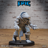 Alligator folk miniature crouching in a long coat and tricorn cap, jaws open wide, holding a human skull in one outstretched clawed hand, ropes and chains wound around the body. Sculpt by Epic Miniatures.