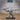 Stone Golem miniature in a wide braced stance, one fist driving forward and the other swinging a heavy studded club outward, angular fractured stone body with a flowing sash, Epic Miniatures.