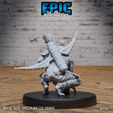 Hobgoblin hunter seen from behind in a low crouch, revealing a large cylindrical quiver of arrows, crossed blades, layered back armour, and a fur-trimmed lower body with bare clawed feet. One arm raised, skull in hand. Sculpt by Epic Miniatures.