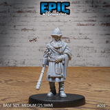 Female guard in a pointed kettle helm and heavy layered cloak, holding a studded mace at her side, short blade at hip, stern expression, standing upright. Sculpt by Epic Miniatures.