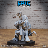 Female orc archer from behind, showing a rope-bound quiver packed with arrows across her back, layered patched cloak, boot buckle detail, and kneeling leg position. Sculpt by Epic Miniatures.