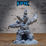 Rear view of the Necro Clock Death Golem showing the cathedral spire crown, shattered brick arms with grasping claws, scrollwork torso detail, and collapsed masonry scenic base. Sculpt by Epic Miniatures.