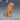 Digital render of a large sitting Winter Wolf resin miniature by Epic Miniatures — unpainted golden-tan resin, showing dense layered fur texture across the chest, neck ruff, and tail, with the head raised and turned alertly to the side. A d20 and a standard 32mm miniature are shown to the right for scale comparison.