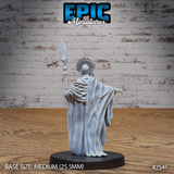 Robed elder figure seen from behind, tall diamond-tipped spear raised in one hand, opposite arm reaching out with claw-like fingers. Wide flowing robes with fine draping detail, fanned headdress visible from the rear. Sculpt by Epic Miniatures.