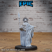 Robed elder figure seen from behind, tall diamond-tipped spear raised in one hand, opposite arm reaching out with claw-like fingers. Wide flowing robes with fine draping detail, fanned headdress visible from the rear. Sculpt by Epic Miniatures.
