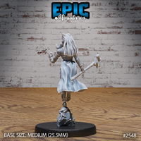 Female tribal warrior-mage seen from behind, long braided locks flowing down her back, axe held at her side, raised hand clutching a small trophy or charm. Tattered skirt with flowing sculpted movement. Rocky sculpted base. By Epic Miniatures.