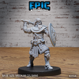 Broad-shouldered armoured warrior raising a long sword overhead in a combat stance, holding a large round decorated shield at the left arm, wearing layered scale armour with a braided head-wrap. Sculpt by Epic Miniatures.