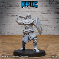 Broad-shouldered armoured warrior raising a long sword overhead in a combat stance, holding a large round decorated shield at the left arm, wearing layered scale armour with a braided head-wrap. Sculpt by Epic Miniatures.