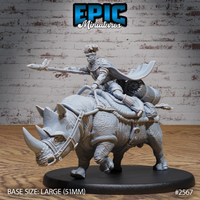 Warrior with braided hair and beaded jewellery riding a saddled war-rhino, spear levelled forward, cape swept back, large saddlebags and bedrolls secured behind. Sculpt by Epic Miniatures.