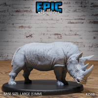 Unpainted grey resin rhino miniature with head lowered, showing deeply textured wrinkled hide across the full body, prominent front horn, and small upright ears. Mounted on a large oval base. By Epic Miniatures.