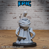 Female noble miniature seen from behind, dramatic layered cape spreading wide, upswept hair visible, raising a serpent-topped staff in one hand. Bone-patterned gown hem visible at base. Sculpt by Epic Miniatures.