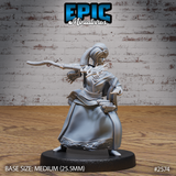 Female tribal seer leaning into an aggressive forward thrust with a long ceremonial staff, wearing layered robes with ornate hem detail, beaded necklace, and a tall wrapped headdress with goggles pushed up above the brow. Scroll cases hang at her belt. Sculpt by Epic Miniatures.