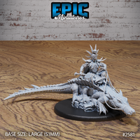 Female voodoo priest in spiked bone crown and ritual armour seated astride a large snarling crocodile, reins held in one hand, sweeping cape behind her. Large decorative oval base. Sculpt by Epic Miniatures.