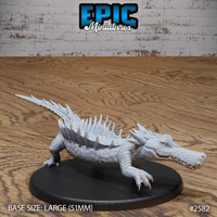 River Crocodile miniature by Epic Miniatures — low-slung reptile with open jaws, broad scaled body, and a row of dramatic dorsal spines running its full length, on a large oval base.