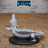 Crocodile miniature viewed from the side and rear, showing overlapping neck scales, a sweeping curved tail with spiked ridges, and a single clawed foot extended outward. Sculpt by Epic Miniatures.