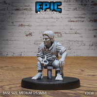 Seated halfling villager miniature by Epic Miniatures, leaning forward on a wooden stool with a small cup or pipe held in one hand, wearing a loose shirt and braces, bare hairy feet resting on the ground, head turned slightly to one side.