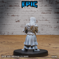 Halfling female villager seen from behind, showing flowing layered skirts, a belted waist, a fur-trimmed collar, and long loose hair falling down her back. Sculpt by Epic Miniatures.