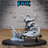 Pumpkin-headed scarecrow mage viewed from behind and below, revealing a large cleaver or axe-like blade at the hip, layered ragged robes, and the erupting icy crystal base piece to the left. Epic Miniatures sculpt.