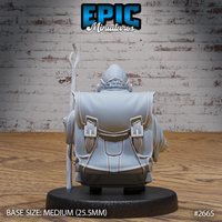 Hamster monk seen from behind, showing a large buckled travel pack across broad shoulders, a flowing robe with deep fabric folds, and the wooden staff extending upward beside him. Round cap visible at the top of the head. Sculpt by Epic Miniatures.
